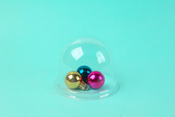 Christmas balls under a transparent dome on a blue background. Protection, isolation concept. Minimal layout