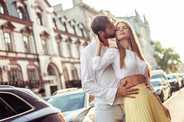 Fototapeta na wymiar Couple in love. Man kisses his girlfriend on cheek in city