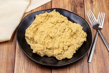 Hummus in a ceramic plate. Dishes of chickpeas, a vegetarian dish.