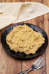 Hummus in a ceramic plate. Dishes of chickpeas, a vegetarian dish.