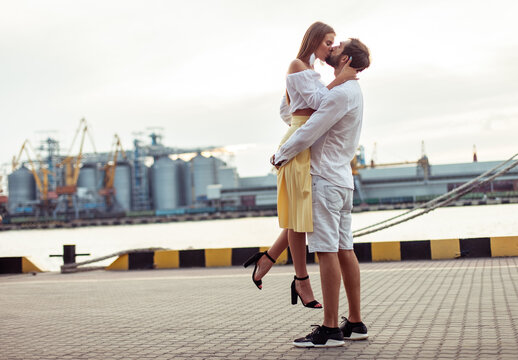 Young couple in love, man and woman kissing in seaport. Romantic love concept