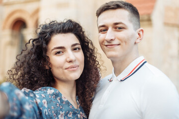 Fototapeta premium Selfie portrait of young couple, guy and girl outdoors