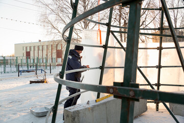 The fitter overlays the metal frame with ice blocks