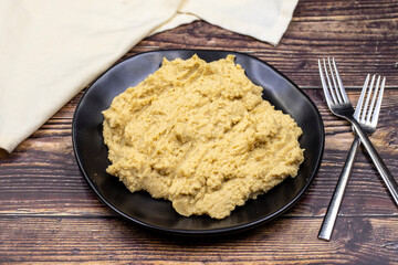 Hummus in a ceramic plate. Dishes of chickpeas, a vegetarian dish.
