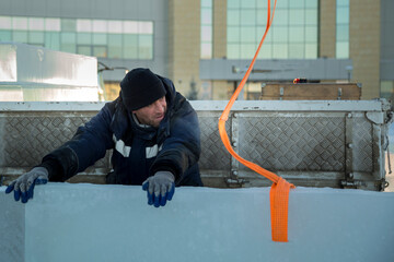 Worker in blue jacket unloading ice panels