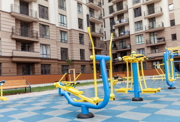 Fototapeta na wymiar Workout playground with exercise machines near a residential building