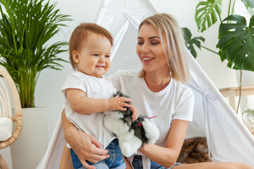 Happy woman mom and her little daughter playing in wigwam at home © splitov27