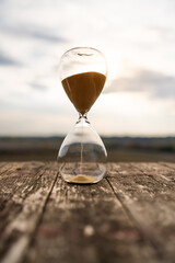 Hourglass on wooden table, time passing concept
