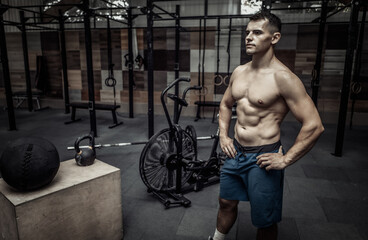 Fototapeta na wymiar Portrait of a muscular man with a naked torso in a modern health club