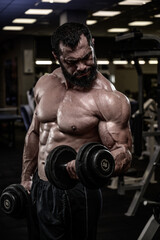 Plakat strong young bearded caucasian muscular man lifting heavy dumbbells in sport gym during fitness bodybuilding workout training