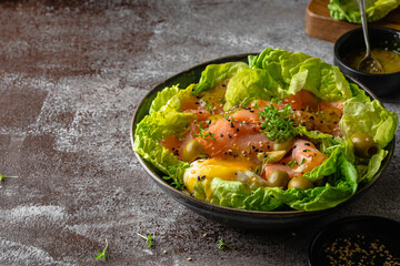 Salmon salad - smoked salmon hard boiled eggs, olives, watercress, sesam and green vegetables on dark brown table. Healthy food. Clean Eating. Paleo diet.