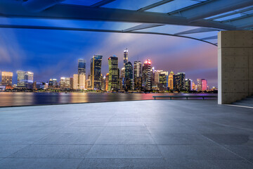 Panoramic skyline and modern commercial office buildings with empty square floor in Shanghai at night, China. empty road and cityscape.