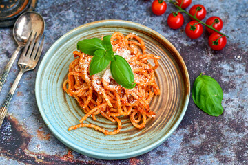 Spaghetti  bolognese .Italian home made meal Fresh  bucatini pasta with tomato sauce, basil, herbs ,parmesan cheese ,fresh cherry tomatoes and parsley on wooden background. Kitchen Poster 