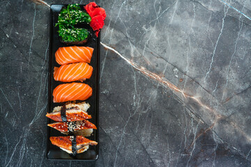 sake sushi, unagi sushi on a serving plate. sushi on a dark background. Japanese food