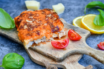 Fish bake preparated in Ticino style with sweet gorgonzola cheese and tomato crust