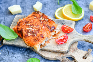 Fish bake preparated in Ticino style with sweet gorgonzola cheese and tomato crust