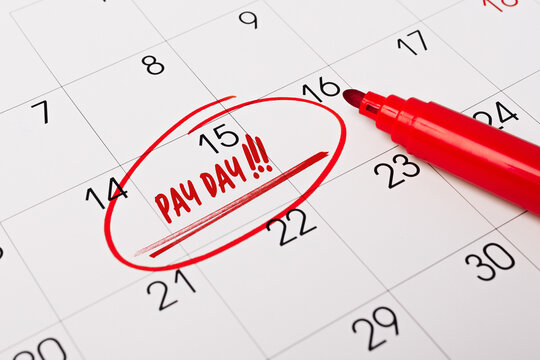 text - Pay day ritten on calendar for remind. Closeup of a personal agenda. Business, finance, savings money, wages, payroll or accounting concept