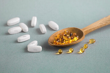 A complex of Mg ( magnesia, magnesium ) and vitamin D ( omega 3 ) capsules for treatment and human health on a light background. Copy space. - obrazy, fototapety, plakaty