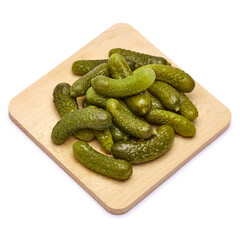 Tasty Whole green cornichons on wooden serving board isolated on a white background