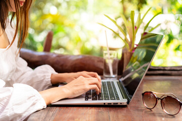 Young woman freelancer traveler working online using laptop while traveling on vacation, Freelance...