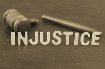 Broken judge gavel and word injustice. Concept of iniquity, injustice and lawlessness.