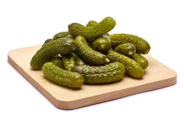 Tasty Whole green cornichons on wooden serving board isolated on a white background