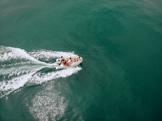 Attractive aerial view of people on a white boat having a rest on the high seas. Large traces of...