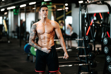 Fototapeta na wymiar Muscular man posing perfect body at gym