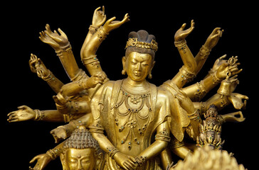 Multi armed Shiva statue isolated on black background with clipping path. Buddha statue with many arms in a Buddhist temple