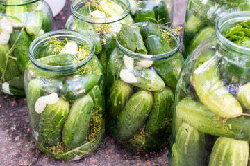 Preparation of canned cucumbers or fermented cucumbers in glass jars. Ingredients for pickling cucumbers. Cucumbers, dill, garlic. Glass jars with pickles.