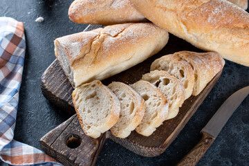 Fresh Baguette Bread on dark background. Homemade french Baguette loafs, top view.