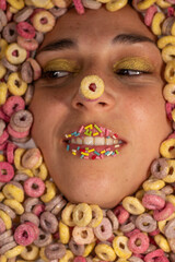 woman's face surrounded by colored sugary cereals and candies on her lips