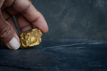 Gold in its origin as gold nuggets in the mine is in the hands of men selective focus.