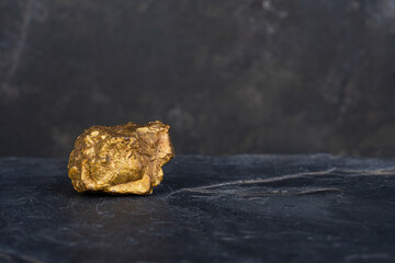 The pure gold ore found in the mine on a stone background.soft focus