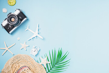 Fototapeta na wymiar Flat lay top view mockup retro camera films, airplane, starfish, shells, hat traveler tropical accessories on a blue background with copy space, Business trip, and vacation summer travel concept