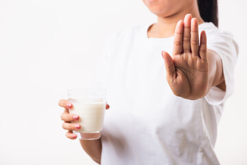 Closeup woman raises a hand to stop sign use hand holding glass milk she is bad stomach ache has...