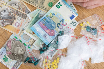 On the table lies currency in banknotes of various countries, and bagged drugs.