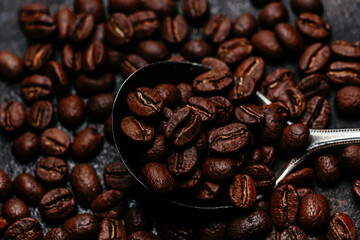 Roasted coffee beans close-up on a dark background. Colombian coffee