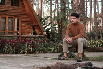 Happy man in sweater traveling in pine tree forest, tourist visit at Doi Bo Luang, Chiang Mai, Thailand, Landmark and popular for tourist attractions. Vacation and journey concept