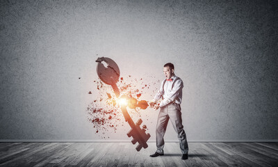Breaking through access concept with man in room crashing concrete key