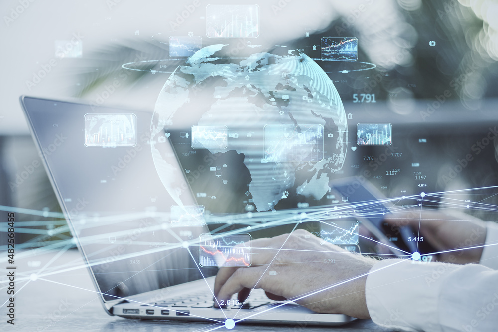 Poster close up of businessman hands using laptop with creative glowing globe hologram with forex charts an