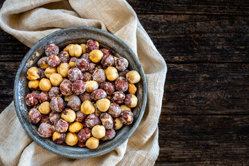 Many hazelnuts on the old rustic wooden bowl