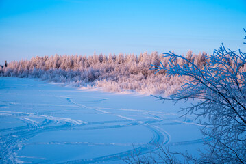 Frozen river in winter forest at sunset, winter landscape