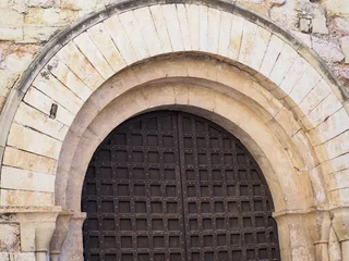 Poster arco de medio punto de la portada de la iglesia de san miguel de montblanch, formado por grandes dovelas, arquivoltas en degración y una fina moldura exterior, tarragona, españa, europa © Nieves
