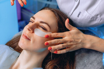 Reduction of bags under the eyes due to patches. A cosmetologist conducts a facial skin care...