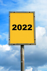 Sign with the date 2022 On a sunny day with blue sky and cloud background