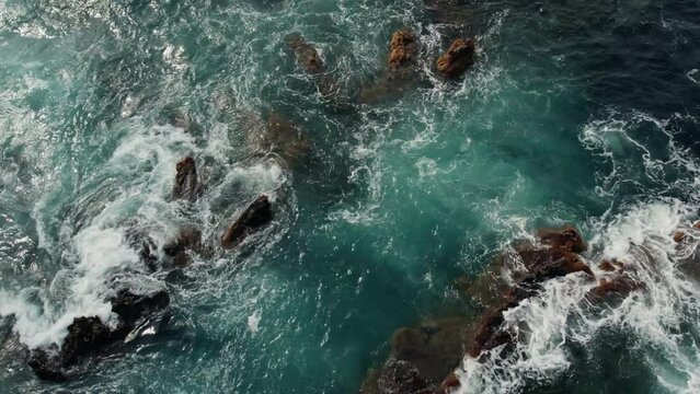 Aerial view of crashing waves on rocks 