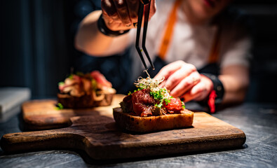 Chef hand decorate plate with food on kitchen in restaurant