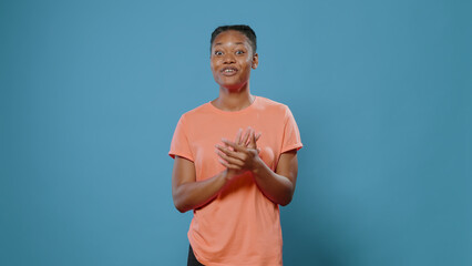 Cheerful person clapping hands and cheering success in studio. Grateful woman doing applause...