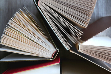 Fototapeta premium Bunch of vintage hardcover books on wooden background. Top view.